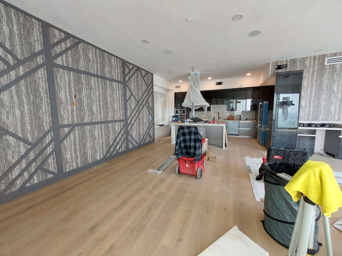 Open commercial space with a grey textured wallcovering and dark geometric lines, install day