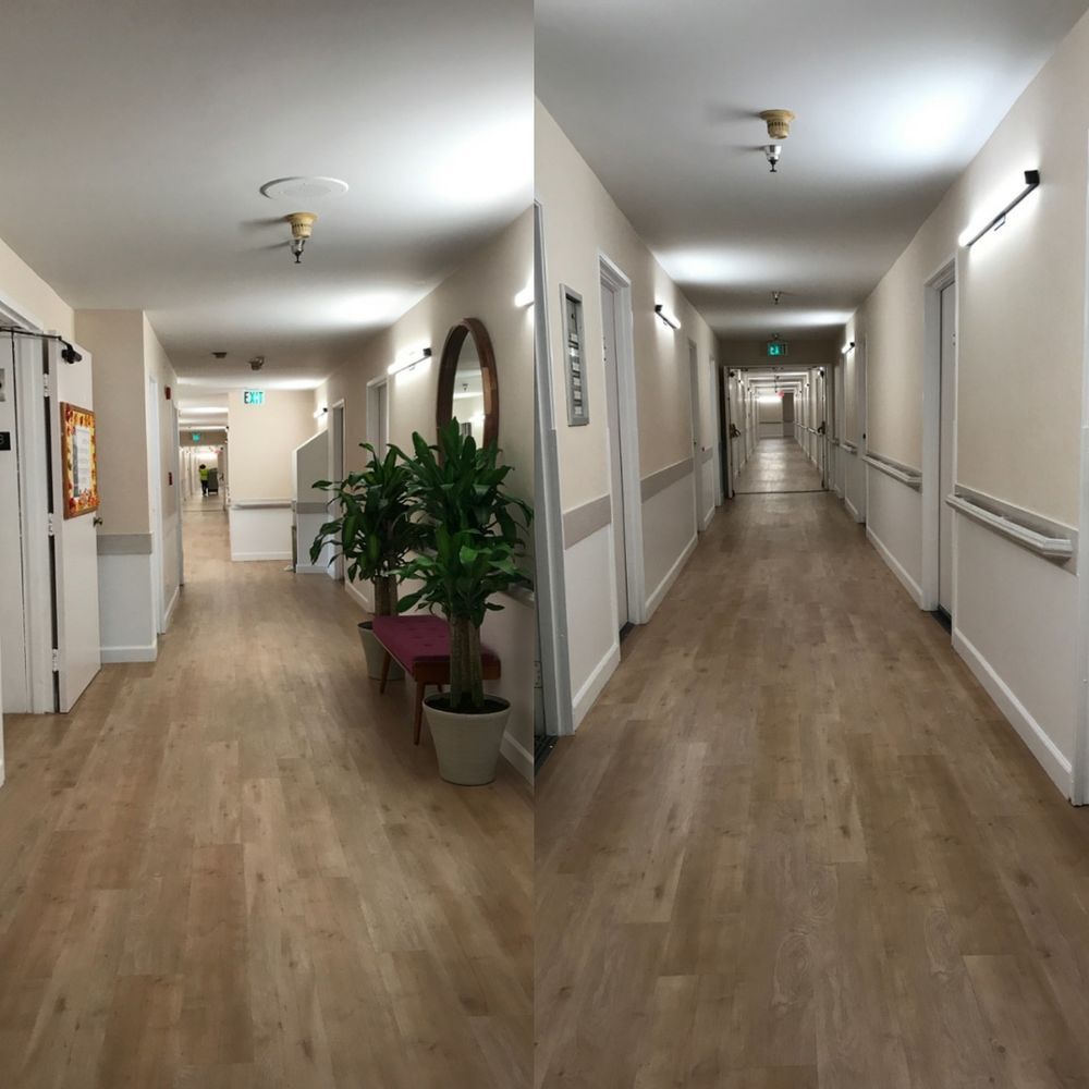 Long hallway in an assisted living home with pale commercial vinyl wallcovering above a chair rail