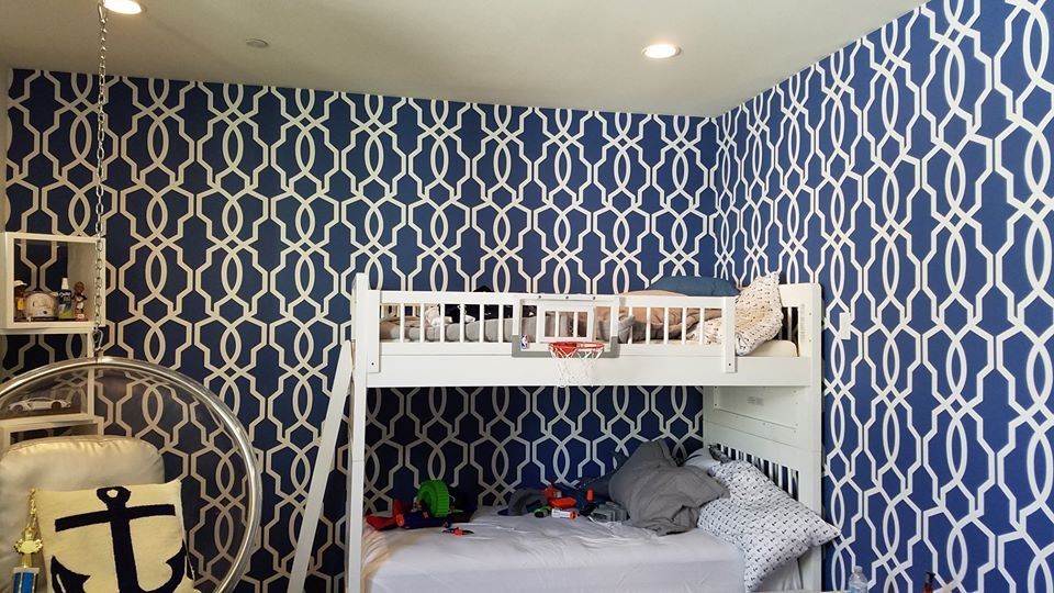 Kids' room with navy and white trellis wallpaper behind a white bunk bed